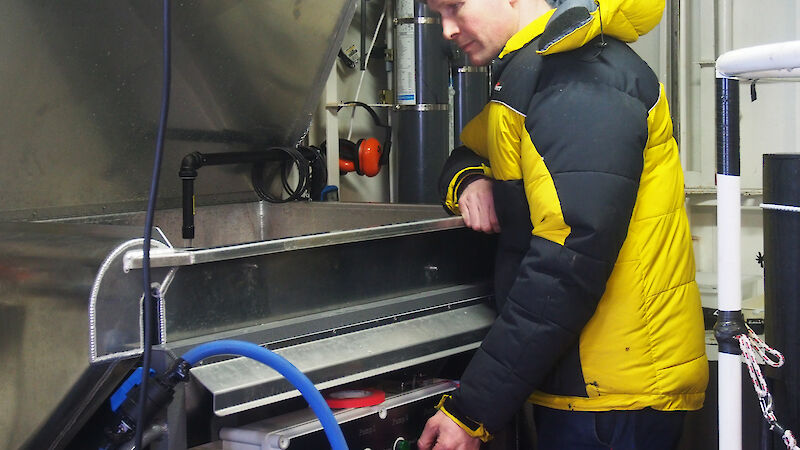 Rob King with a filter table, connected to a fish pump, set up on the Aurora Australis
