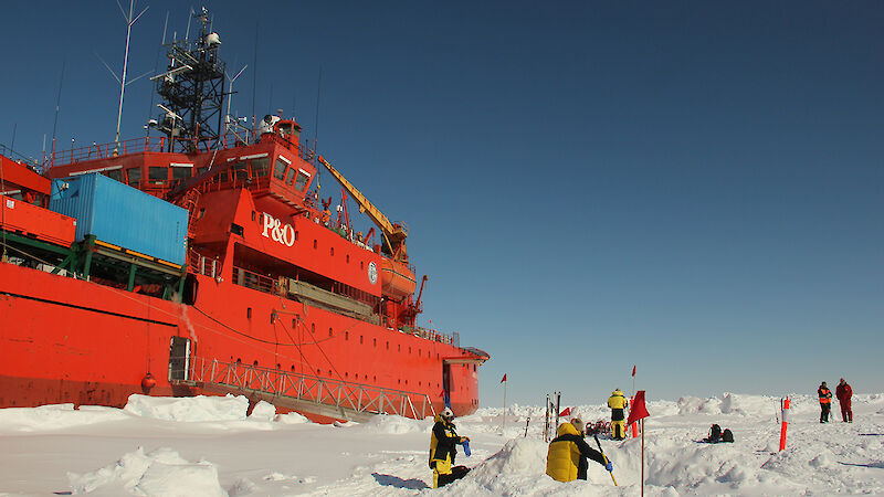 Scientists collect samples on the sea ice beside the ship Aurora Australis.