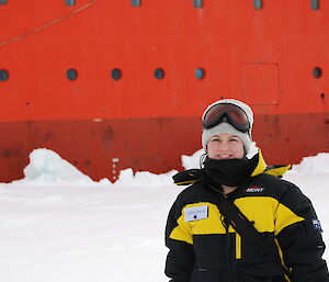 PhD student Caitlin Gionfriddo standing on the sea ice beside the ship Aurora Australis in 2012.