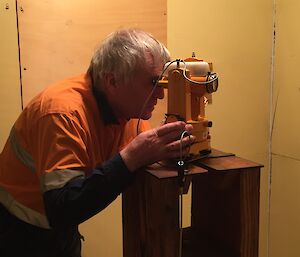 Mawson Communications Technician Tony Harris takes a measurement with the declination-inclination magnetometer mounted in the middle of the room.