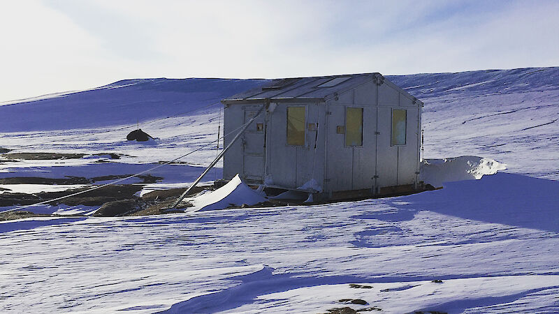 The ‘magnetic absolute hut’ — a small wooden hut sitting in isolation on a plateau at Mawson.