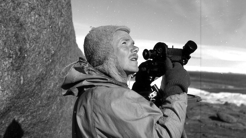 Weather observer, Bob Dingle, using a theodolite near Mawson Station in February 1955.