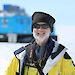 Antarctic Medal recipient Dr John Cadden standing in front of a blue Hagglund in Antarctica.