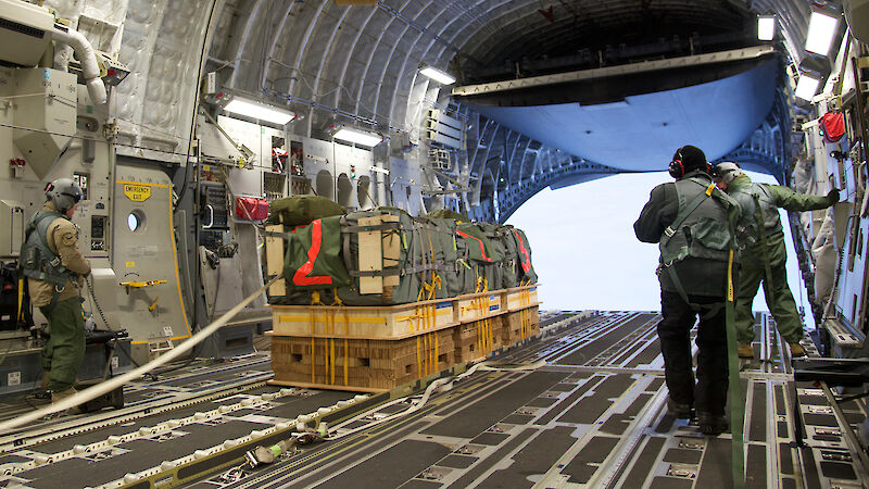 Pallets of cargo being deployed out the back of a C17A aircraft over Antarctica.