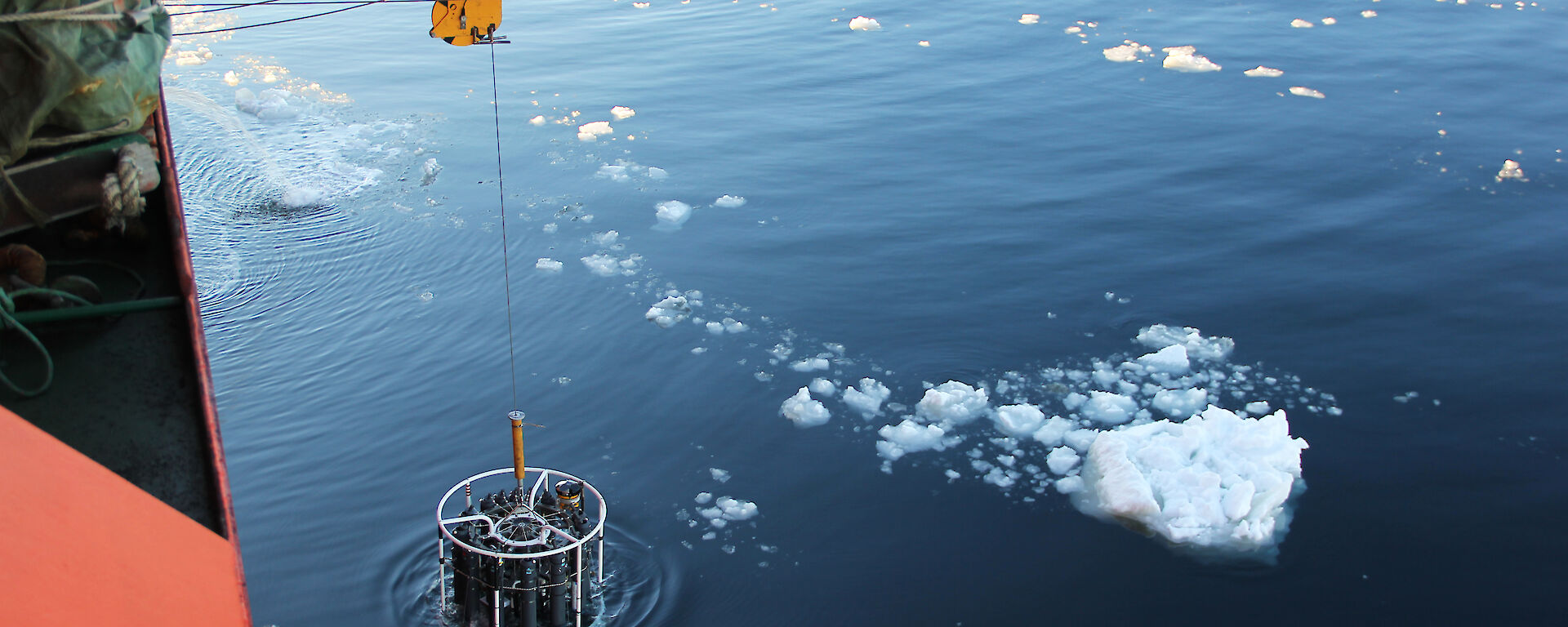 A Conductivity Temperature and Depth (CTD) instrument is lowered over the side of the ship