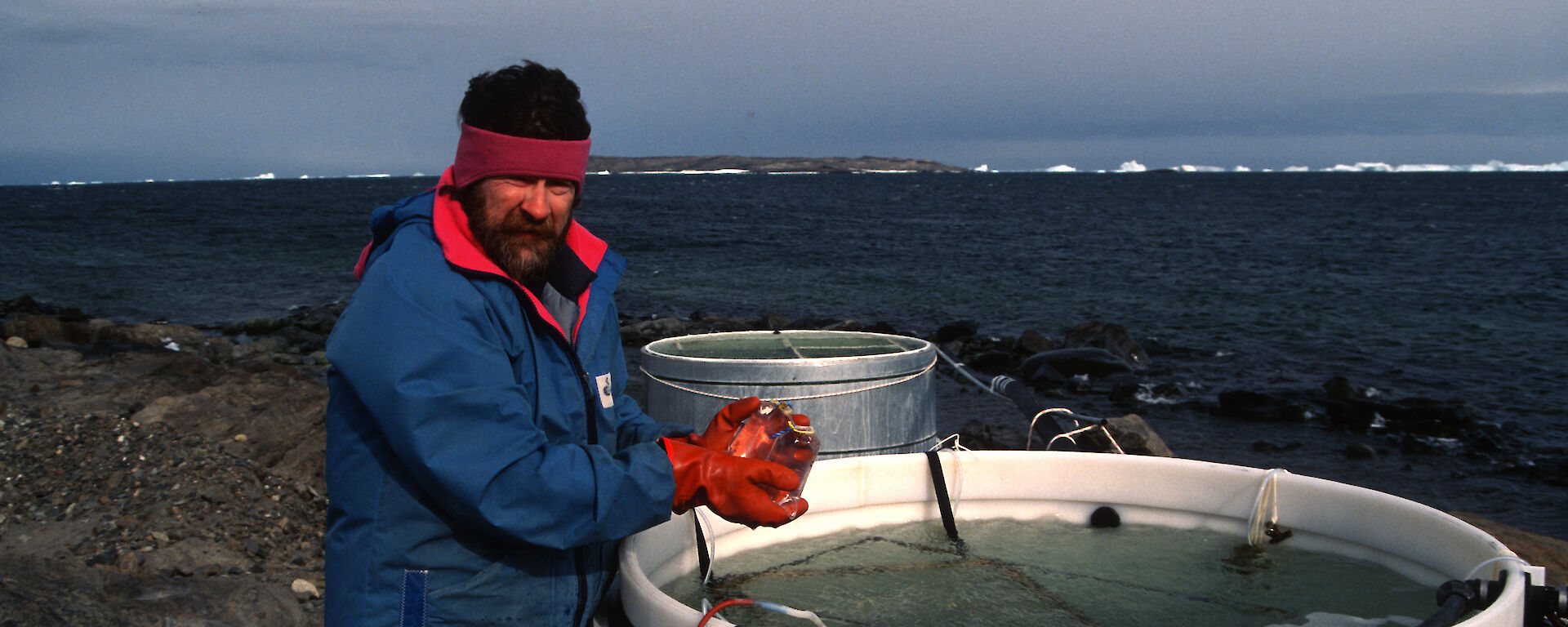 Dr Davidson with some seawater-filled tanks on the foreshore at Davis