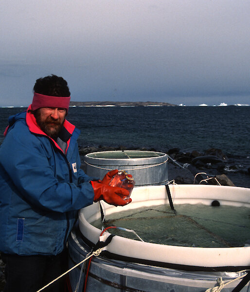 Dr Davidson with some seawater-filled tanks on the foreshore at Davis