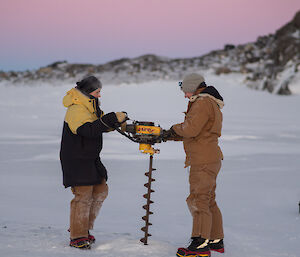 Sarah and Alyce drill for water samples on an Antarctic lake