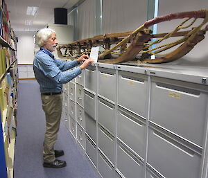 Antarctic Division library assistant, Graham Watt, inspects a man haul sledge