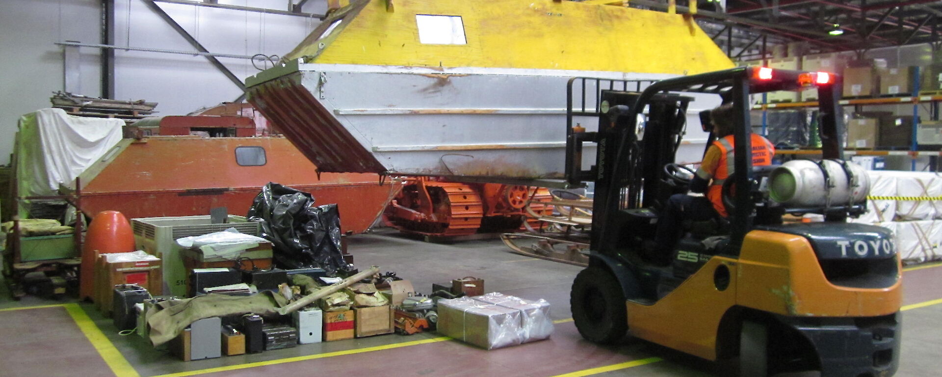 A forklift lowers a barge caravan into place on the warehouse floor
