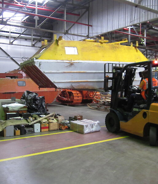 A forklift lowers a barge caravan into place on the warehouse floor