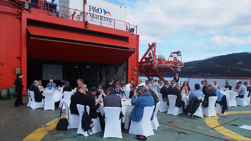 Members of the Hobart Antarctic community enjoy lunch on the helideck of the Aurora Australis to celebrate her 25th birthday.