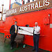 Mr Jason Mundy, General Manager of the Australian Antarctic Division’s Strategies Branch (left) presents the Wiluna paddle to the Master of Aurora Australis, Captain Murray Doyle (right).