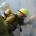 Expeditioners practice using breathing equipment as they enter a burning building.