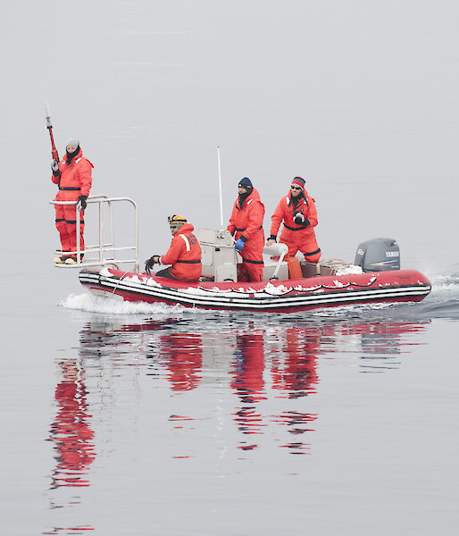 The Australian-American tagging team dressed in red immersion suits in a small boat