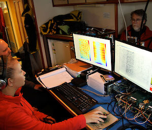 The acoustics team analyse whale sounds through their computers onboard the ship