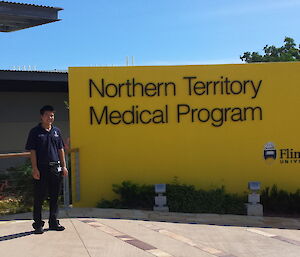 Felix Ho standing at the entrance to the Flinders University Northern Territory Medical Program building
