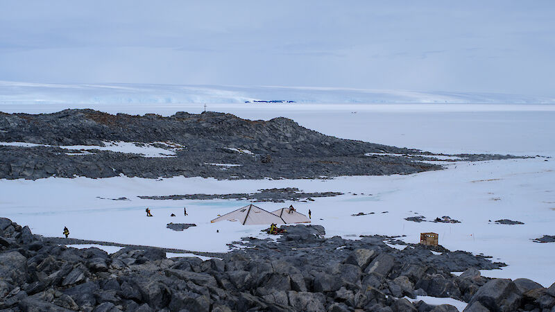 View of the roofs of Mawson’s Main Hut, from a rocky outcrop at Commonwealth Bay