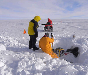 Fuel drums being extracted from the snow with a quad bike.