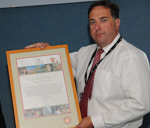 Dr Jeff Ayton accepts the Australia Day Award on behalf of the Crisis Management and Recovery Team and the Davis Station Team.