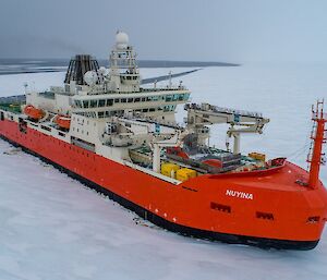 Aerial view of RSV Nuyina pushing through ice in Antarctica.