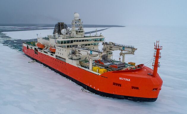 Aerial view of RSV Nuyina pushing through ice in Antarctica.