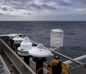 Ship equipment in the foreground with the sky and ocean behind.
