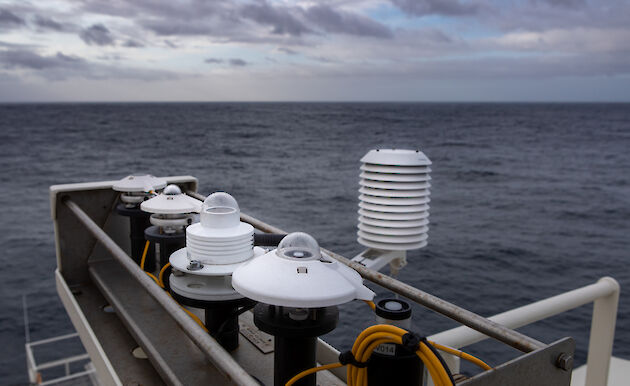 Ship equipment in the foreground with the sky and ocean behind.