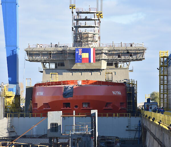 The Nuyina in the wet dock crowned with a crows nest, 32 metre-long navigation bridge and science observation deck.