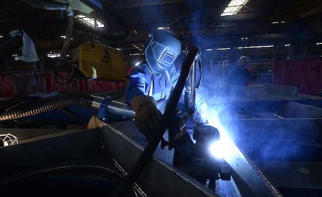 Tradesperson working on steel with bright flash