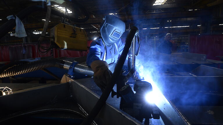 Tradesperson working on steel with bright flash