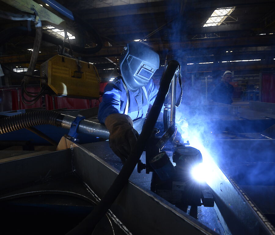 Tradesperson working on steel with bright flash