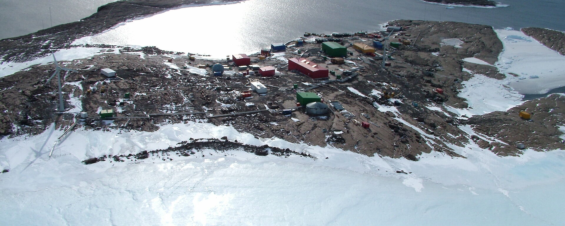 Aerial photograph showing red station buildings and the harbor behind them.