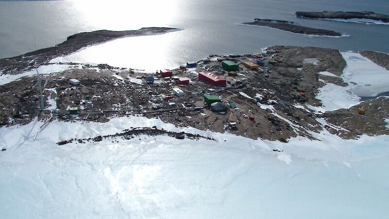 Aerial photograph showing red station buildings and the harbor behind them.