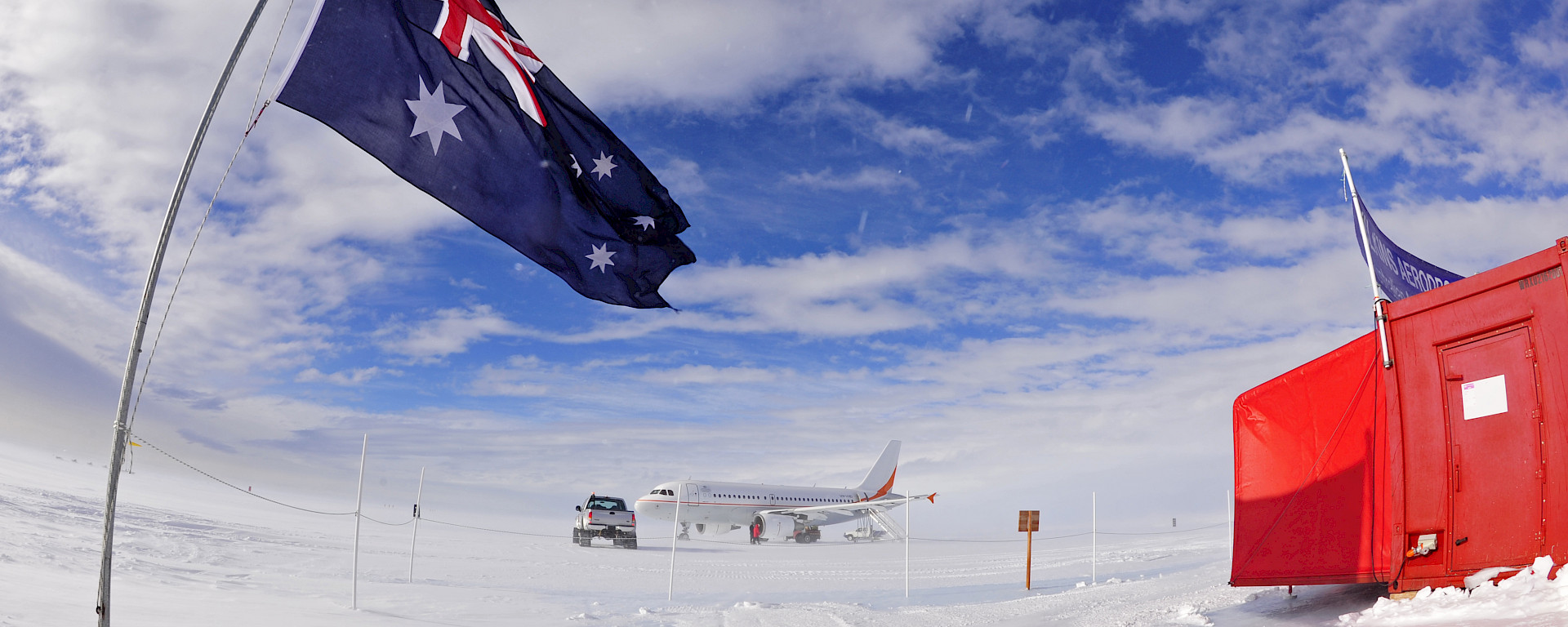 Australian flag flying with aircraft in distance.