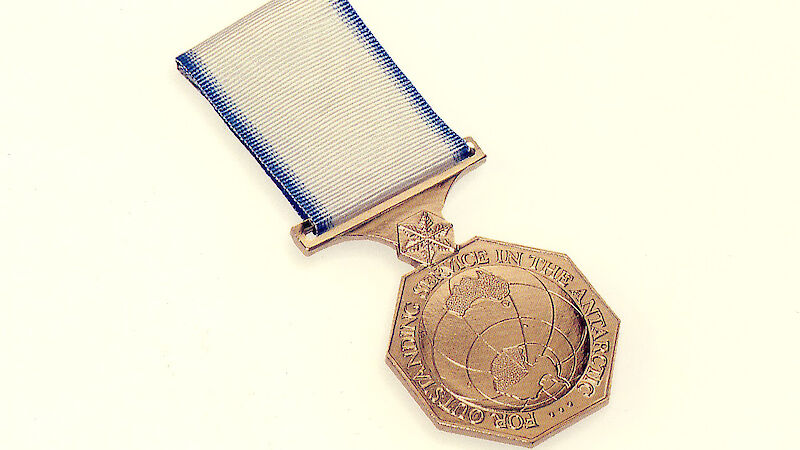 A bronze medal depicting a map of Antarctica and the words ‘For Outstanding Service in the Antarctic'