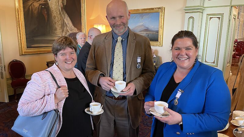 The AAD Head of Division stands with a scientist and an engineer who have medals pinned to their chest