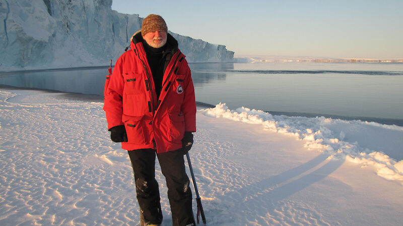 Man standing on ice in red jacket