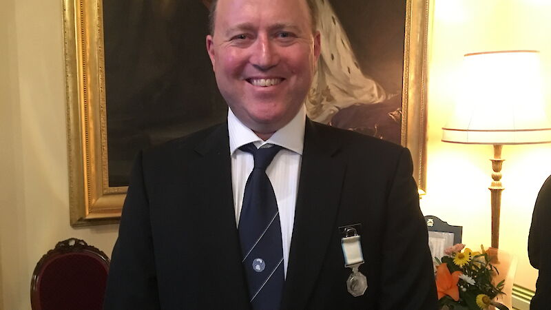 Kym Newbery poses wearing his Antarctic Medal