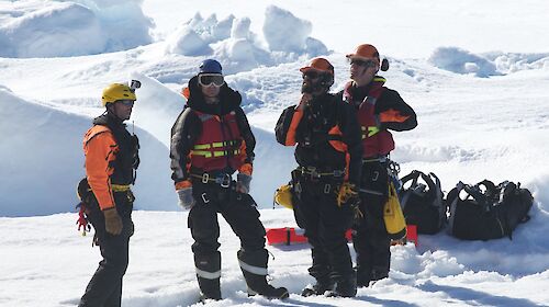 Rescue team preparing landing spot on the ice for the helicopter