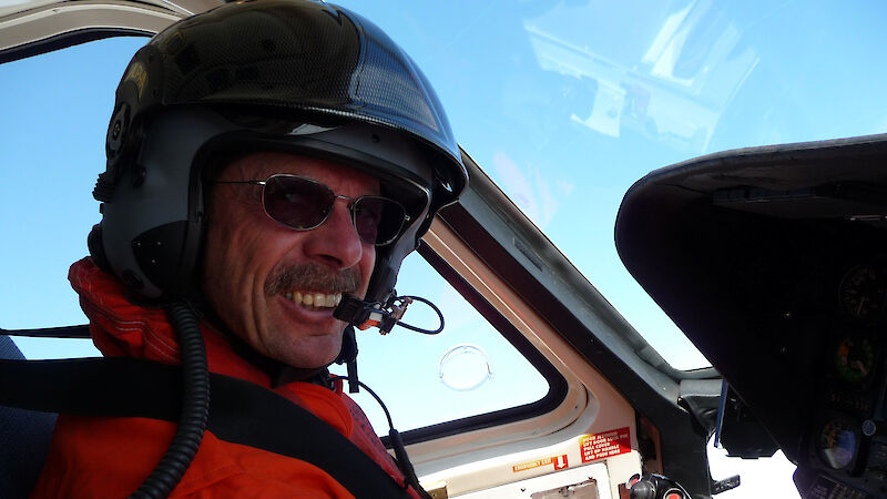 Pilot in cockpit of aircraft viewed from exterior