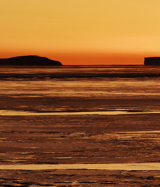 Sunset with the distinctive triangular shaped outline of Nelly Island on horizon