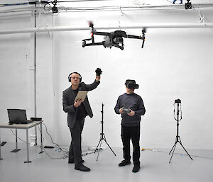 Two artists in the digital studio. One flies a drone, the other wears a VR headset.