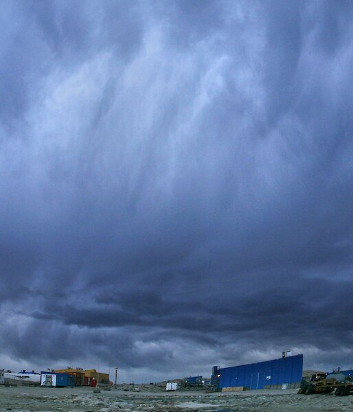 Huge grey and white choulds roll hang low over the red buildings at Casey.