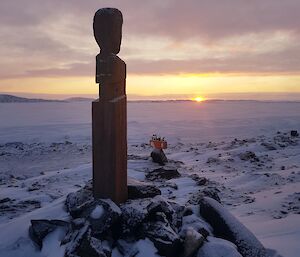 A sculpture in the foreground looks over a showy landscape