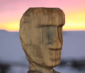 A carved wooden head tops a post in Antarctica.