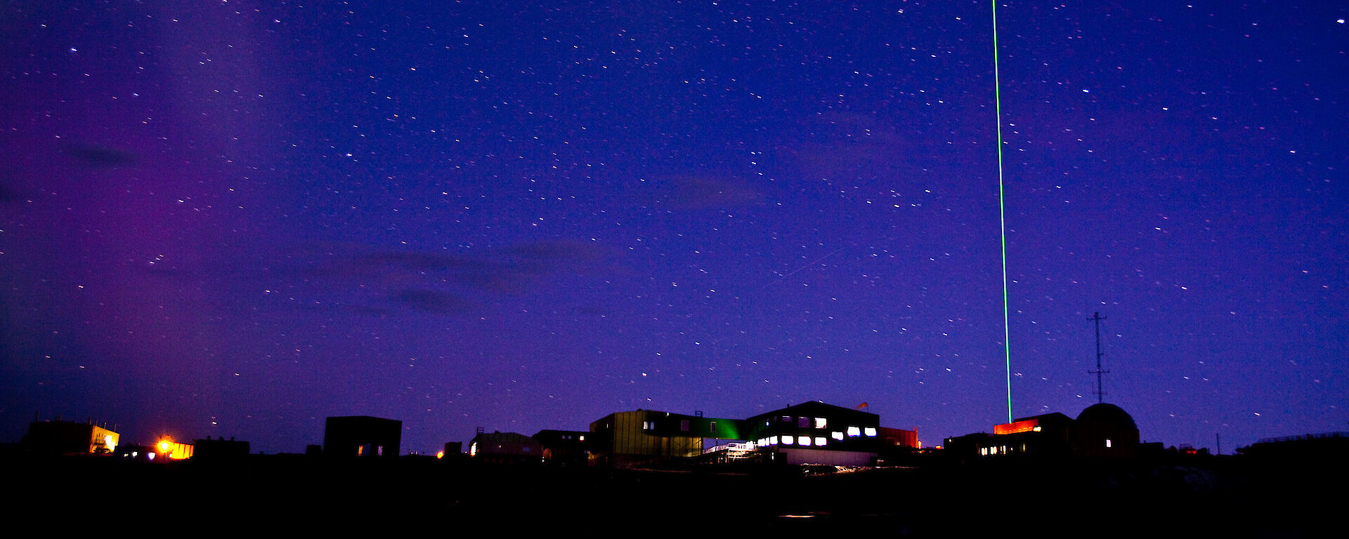 A night view of Davis station showing the LIDAR laser piercing the sky