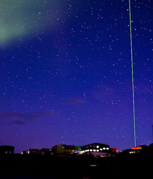 A night view of Davis station showing the LIDAR laser piercing the sky