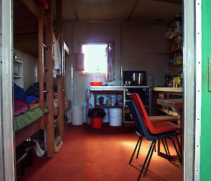 Internal view of hut, chair, bunks & cooking facilities