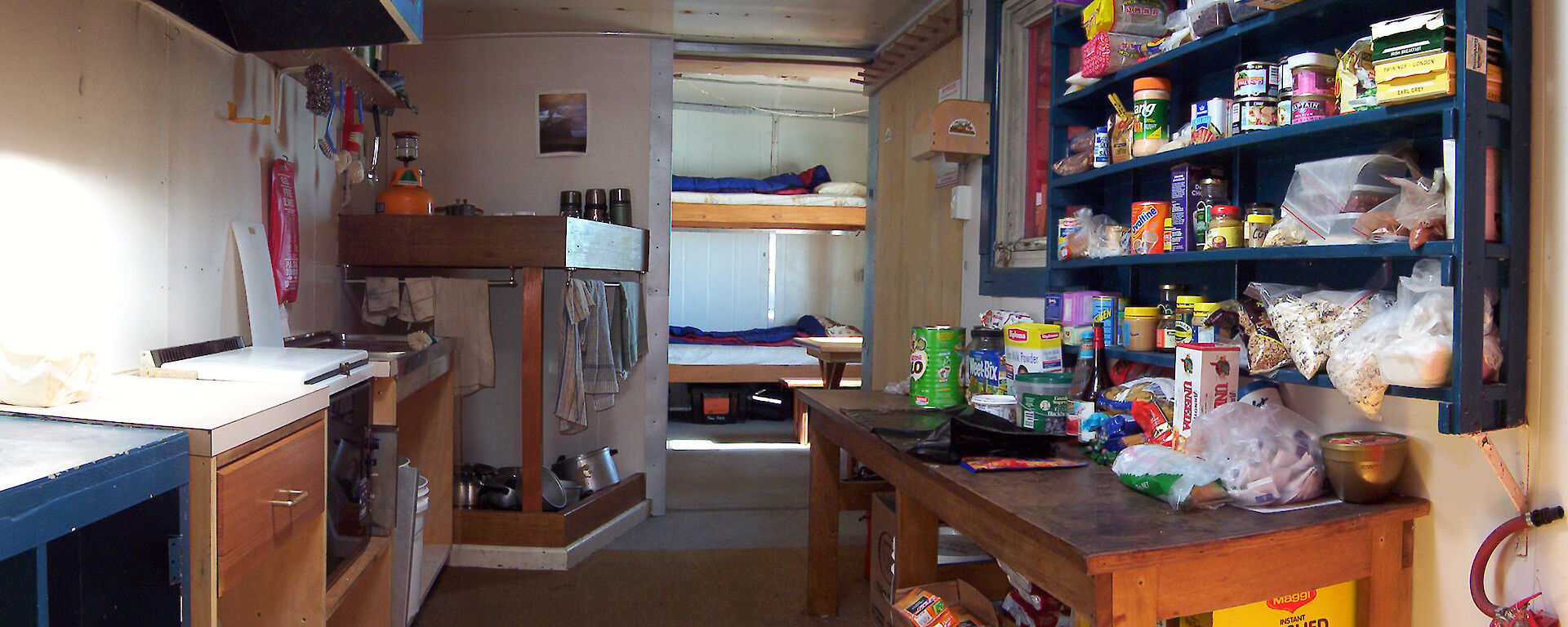 Internal shot of hut — food shelves, cooking facilities & bunks